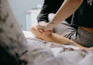 Casal na cama com mãos dadas